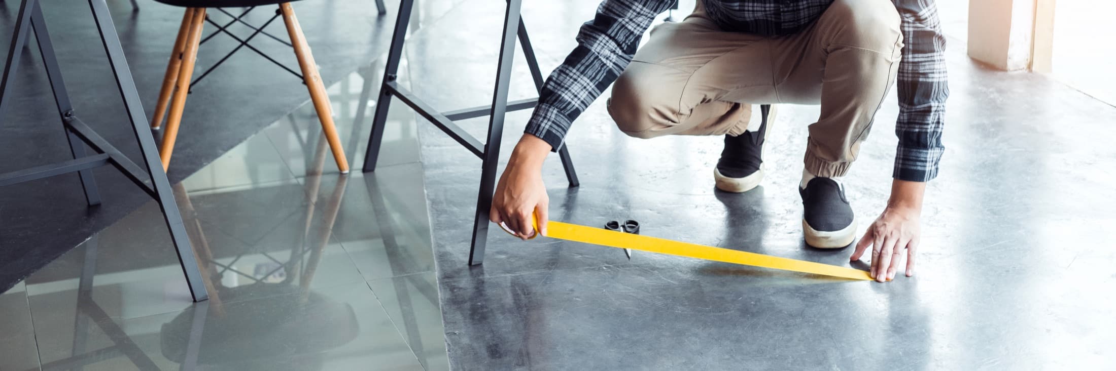 A field technician measuring a polished commercial floor — the geographic discipline of a national inspection program.
